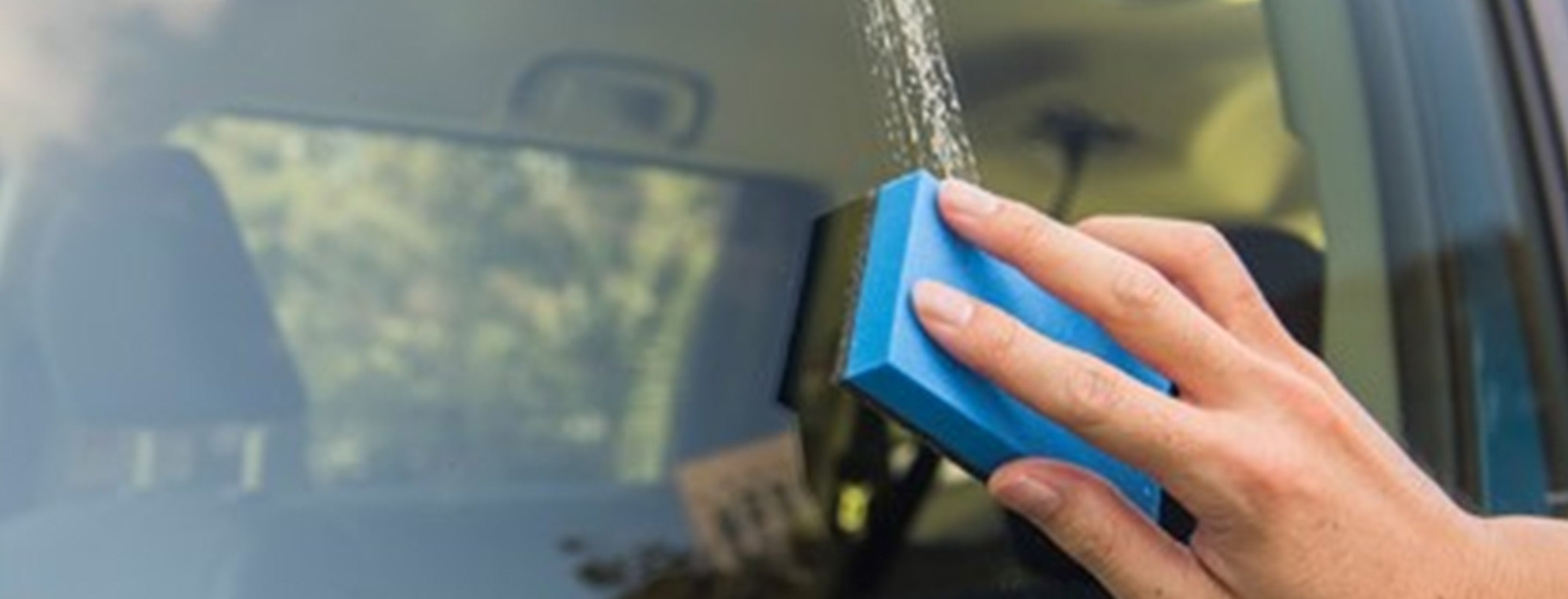 blue sponge being used on a car window 